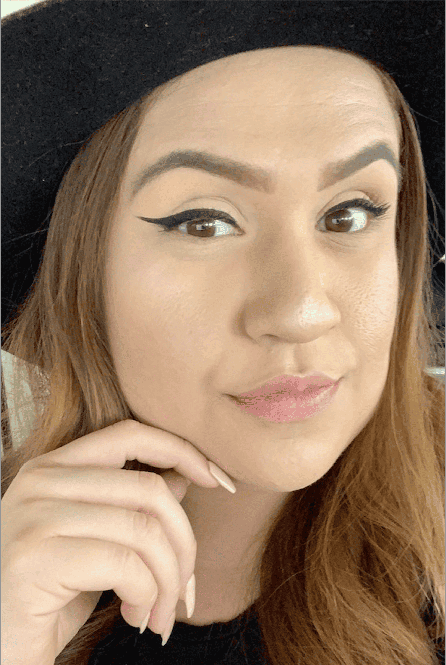 Woman taking a selfie with winged eyeliner.